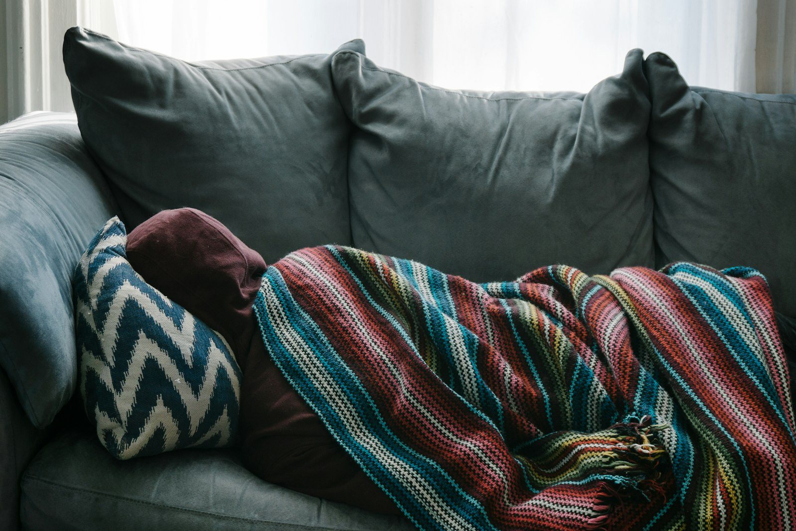 A person resting unwell on a sofa