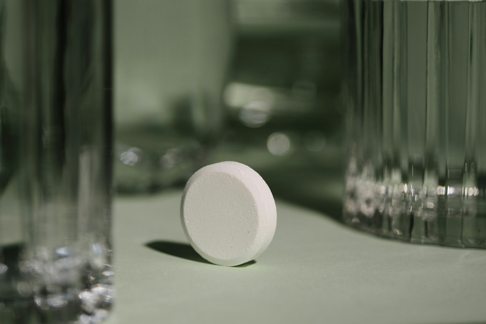 A tablet beside a glass of water