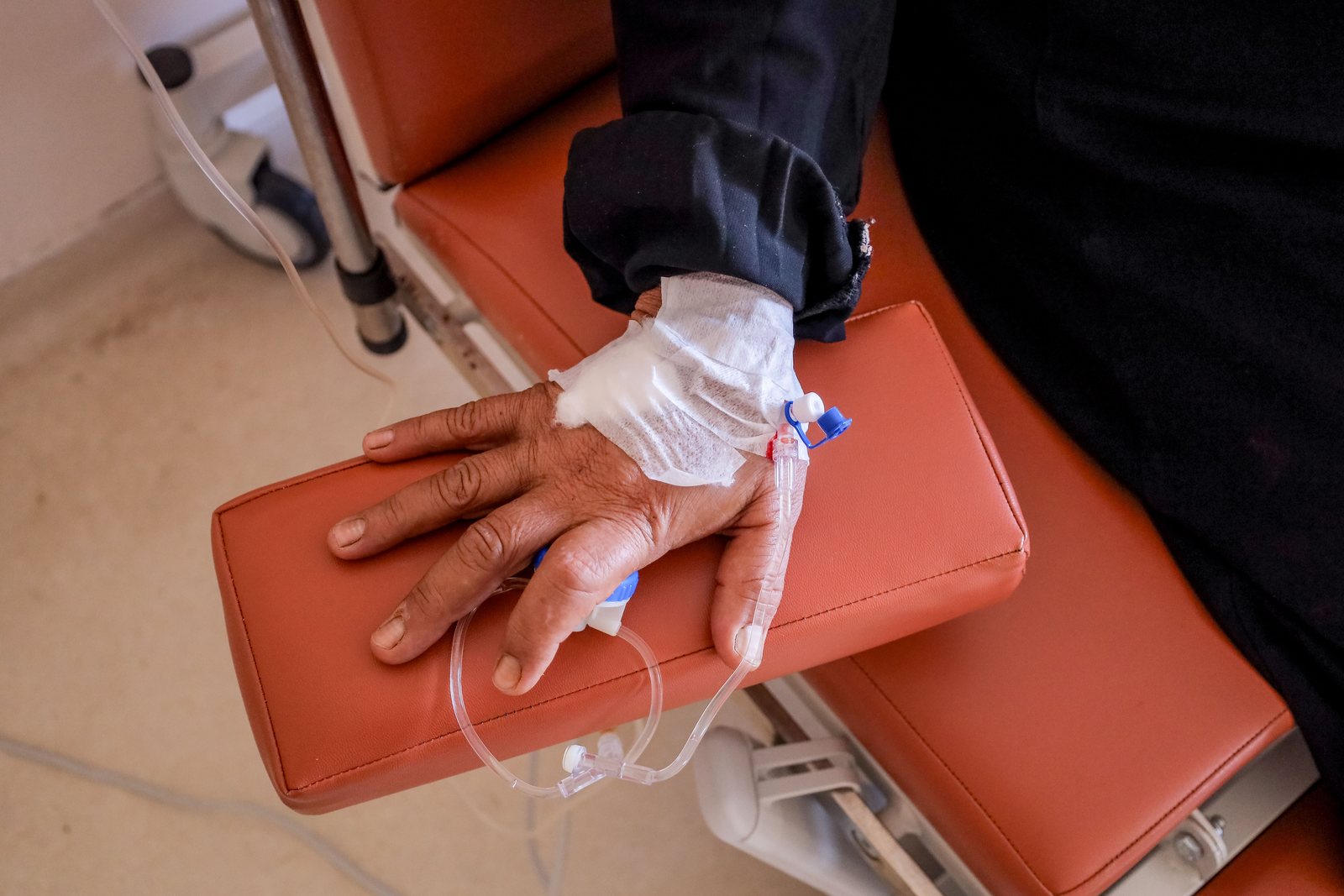 A patient receiving an intravenous infusion while seated