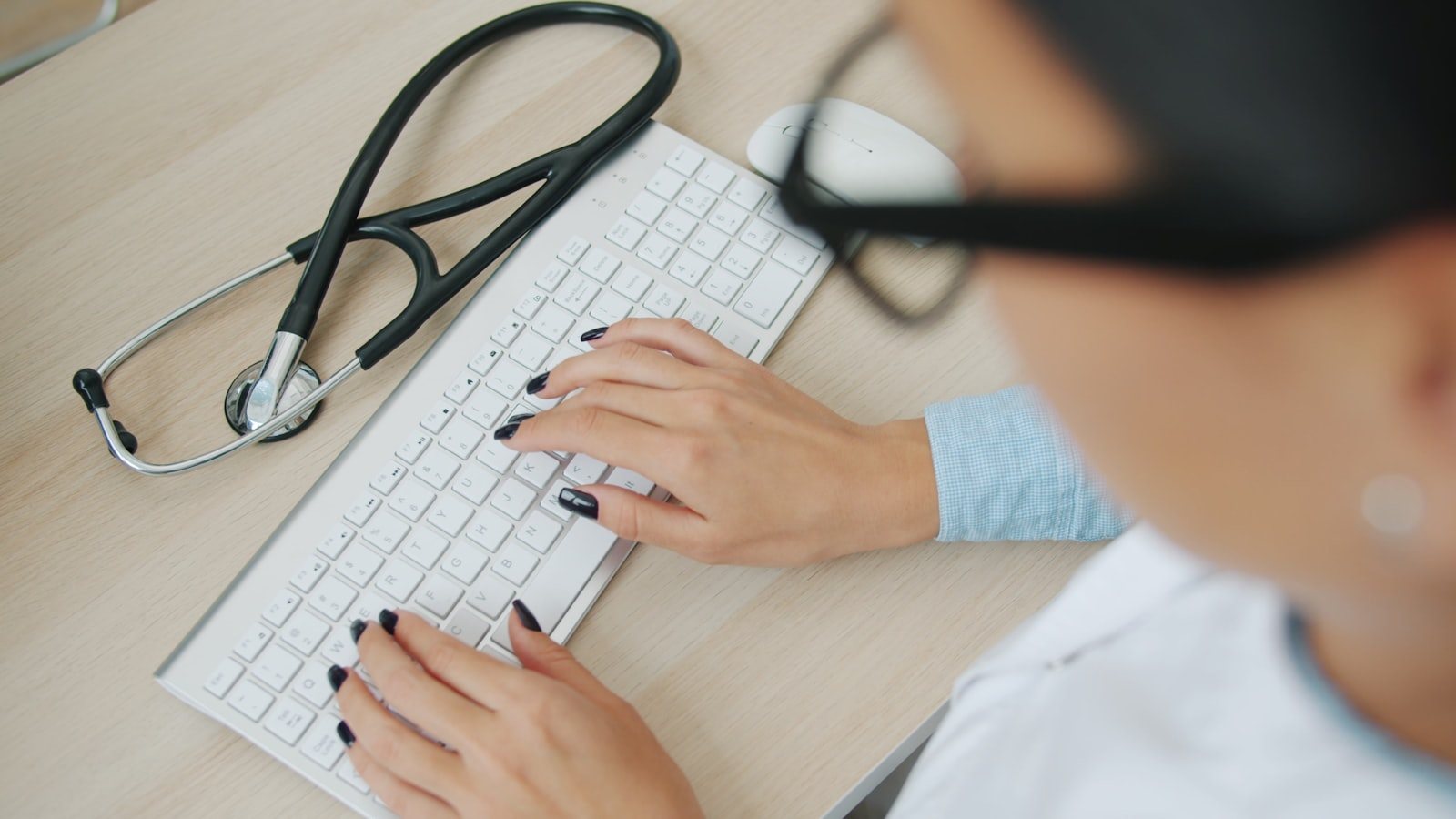 A clinician updating records at a computer