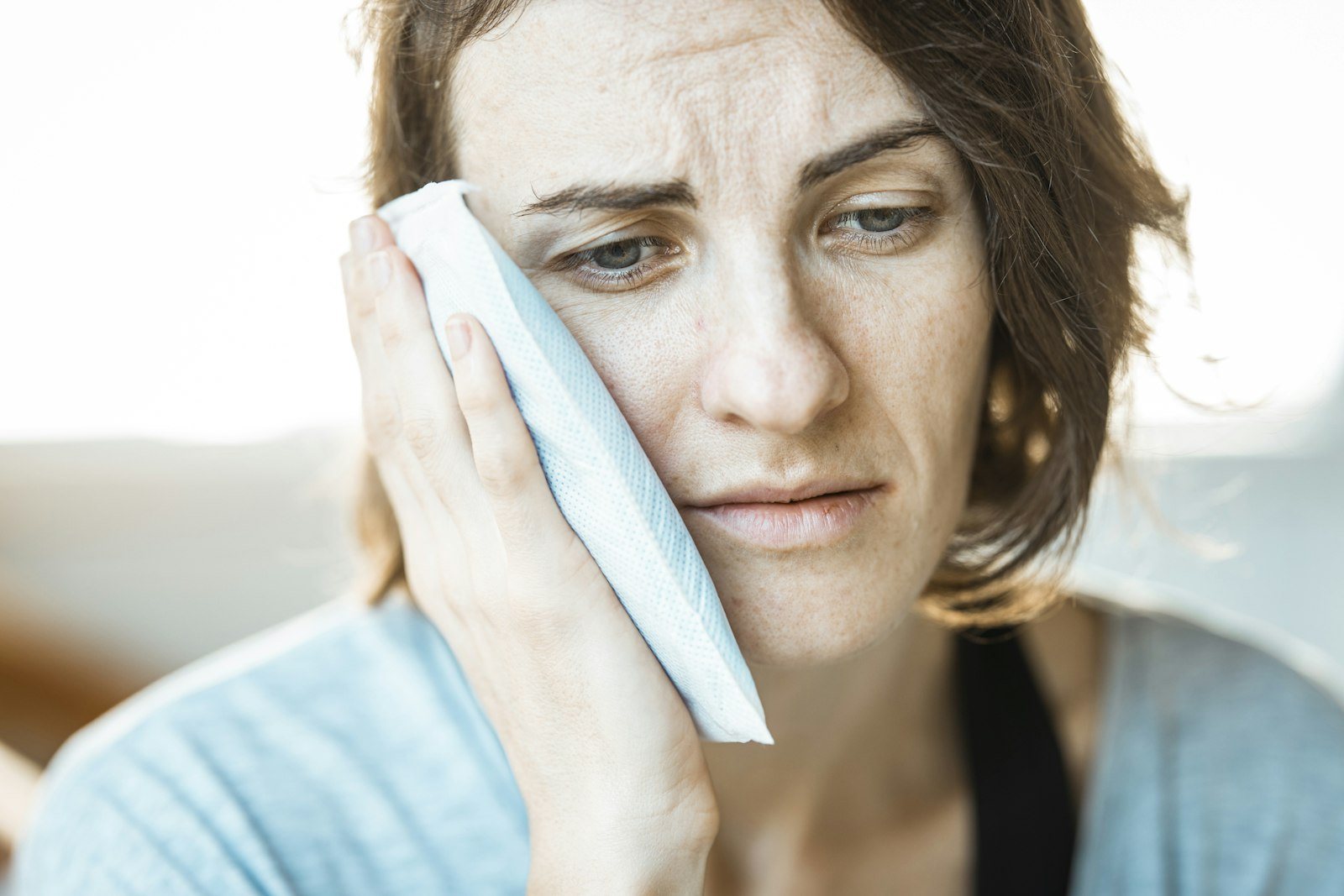 A person wiping their eye with a tissue