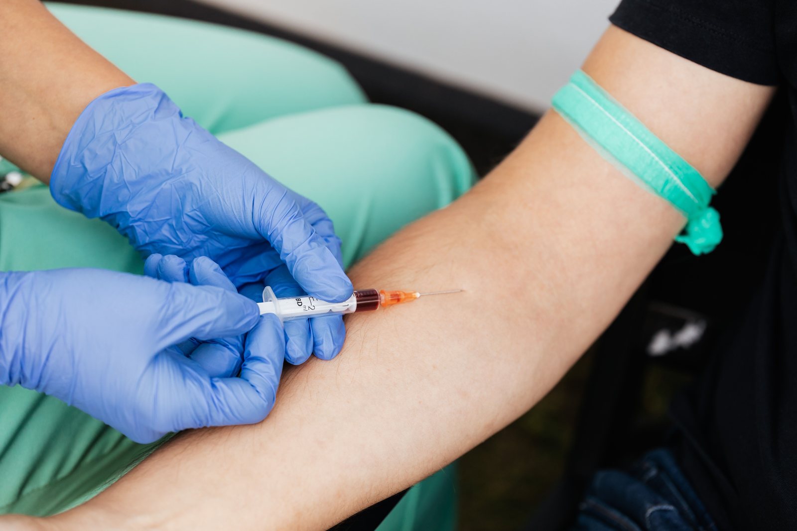 A blood sample being drawn from a patient arm during a study visit