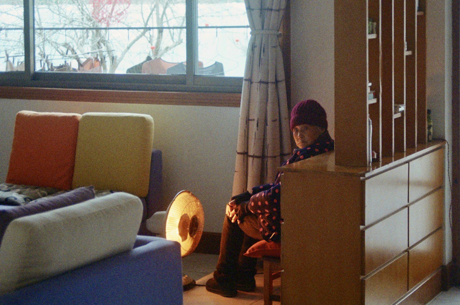 An older adult sitting by a window at home