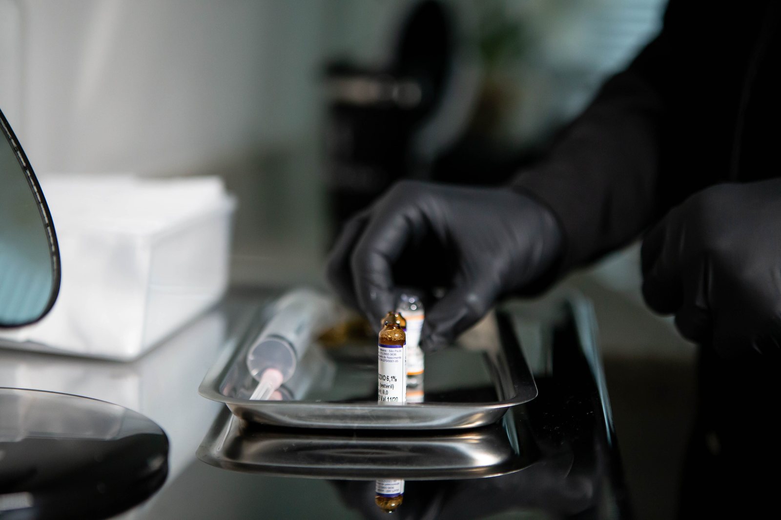 A vaccine vial and syringe on a clinic tray
