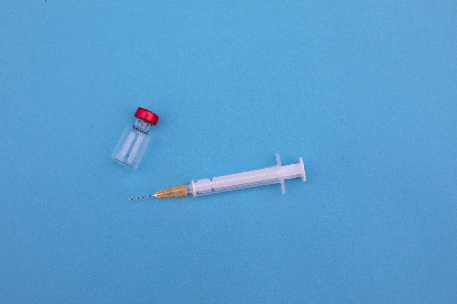 A vaccine vial and syringe on a clinic tray