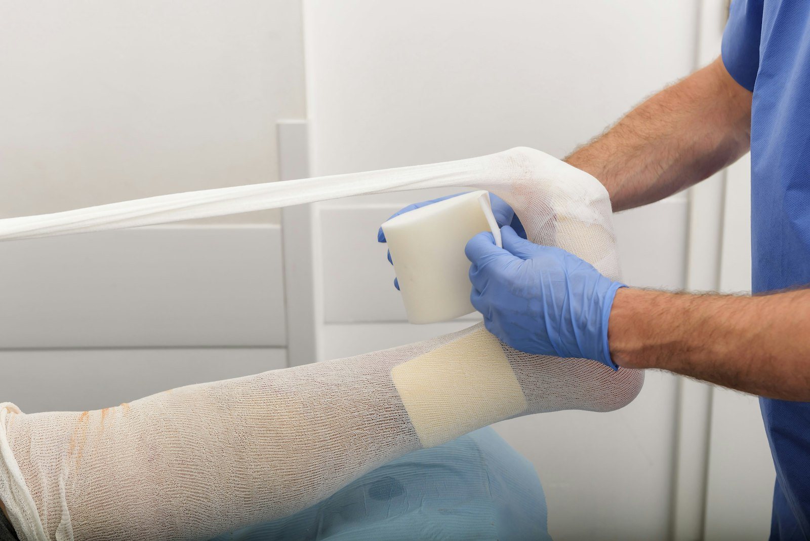 A clinician applying a bandage during wound care