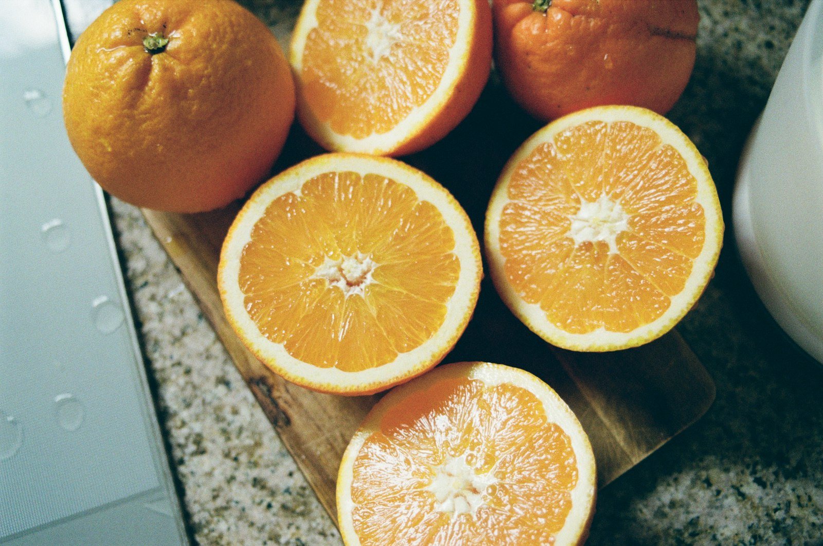 Citrus fruit, whole and halved, on a wooden board
