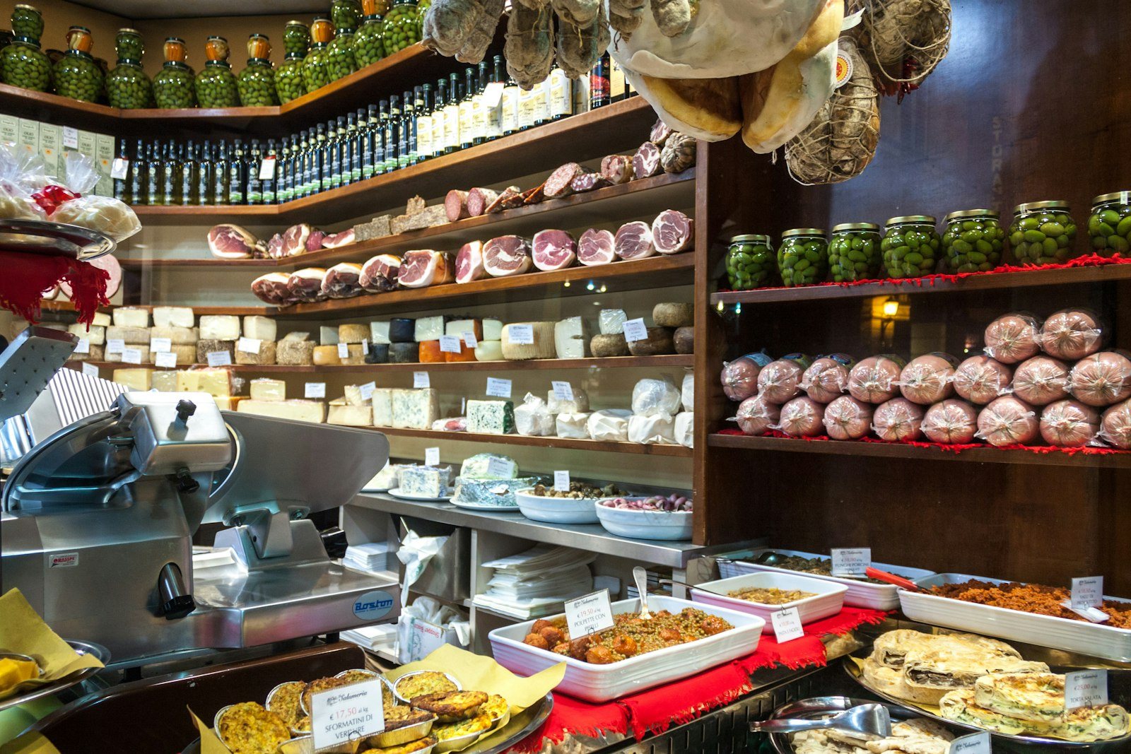 A delicatessen counter of cheeses and prepared foods