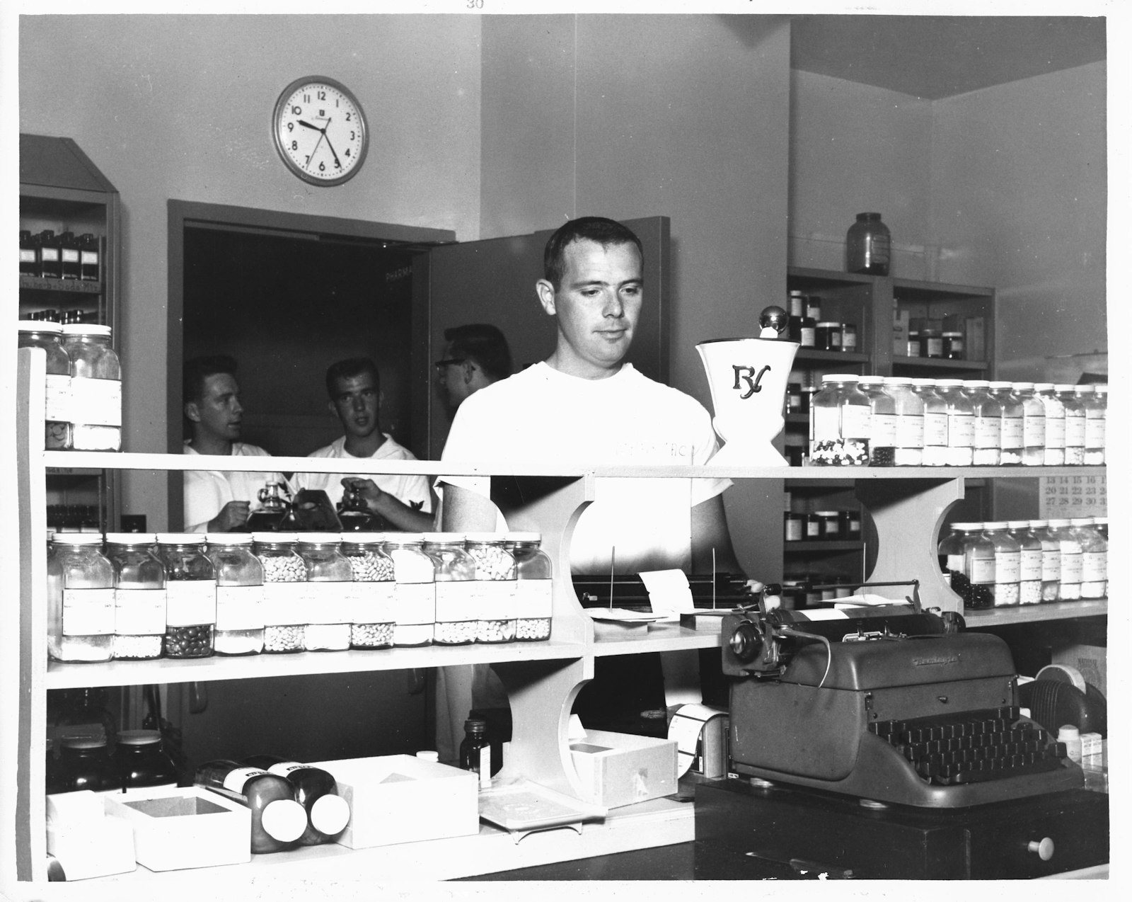 A pharmacy interior lined with shelves of medicine bottles