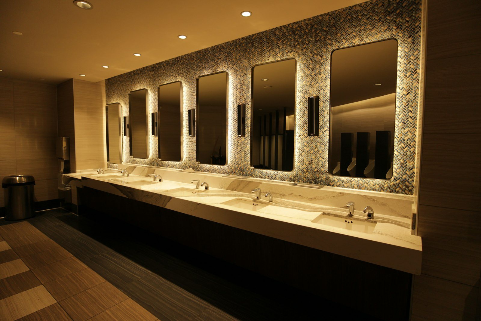 A public washroom with a row of sinks