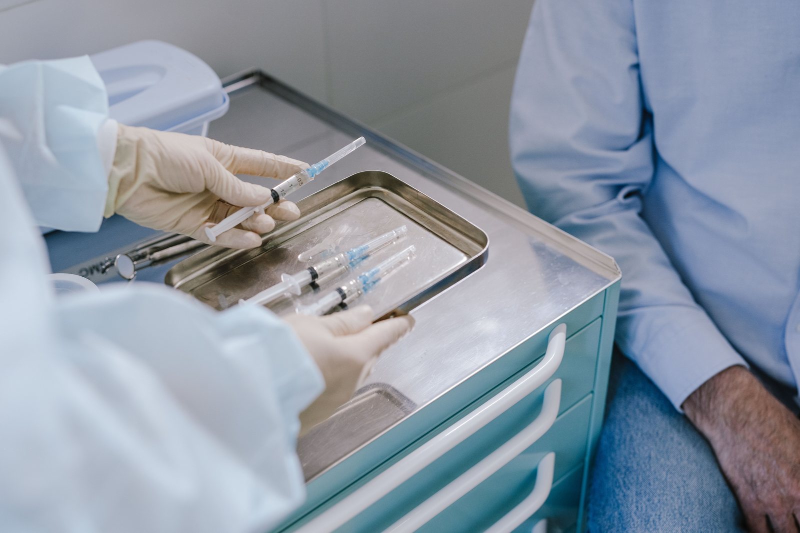 A clinician preparing an injection on a clinical tray