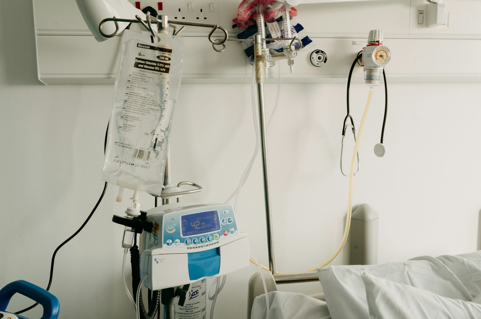 An intravenous drip bag on a stand in a hospital room