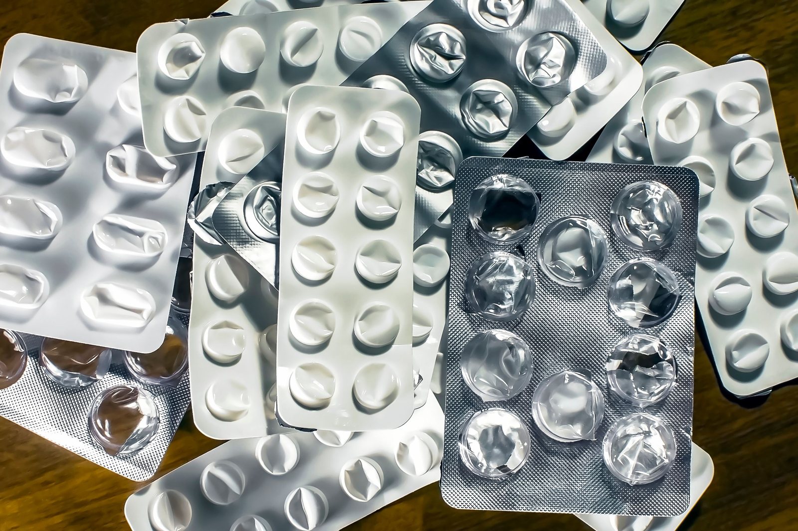 Used blister packs on a wooden surface