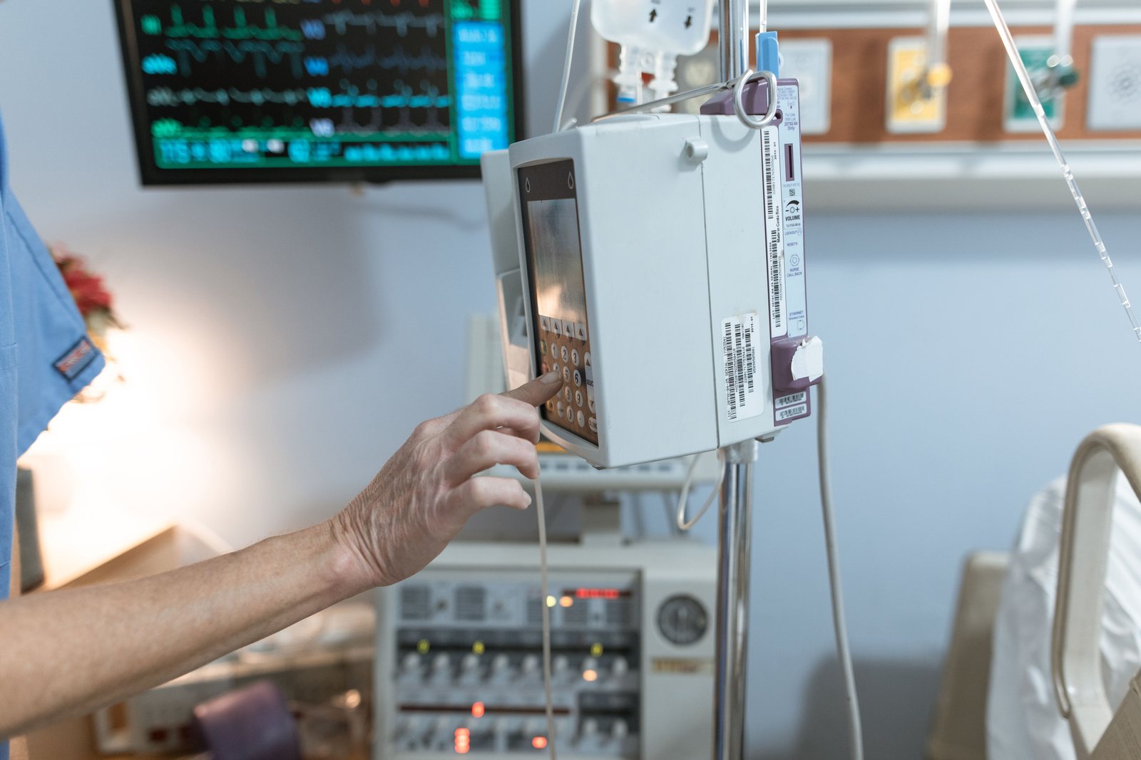 A healthcare worker operating an infusion pump