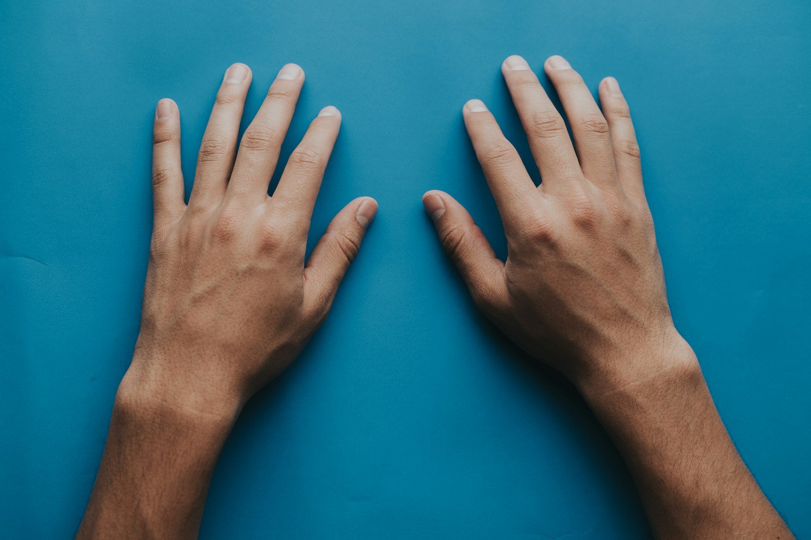 Two hands resting flat on a surface