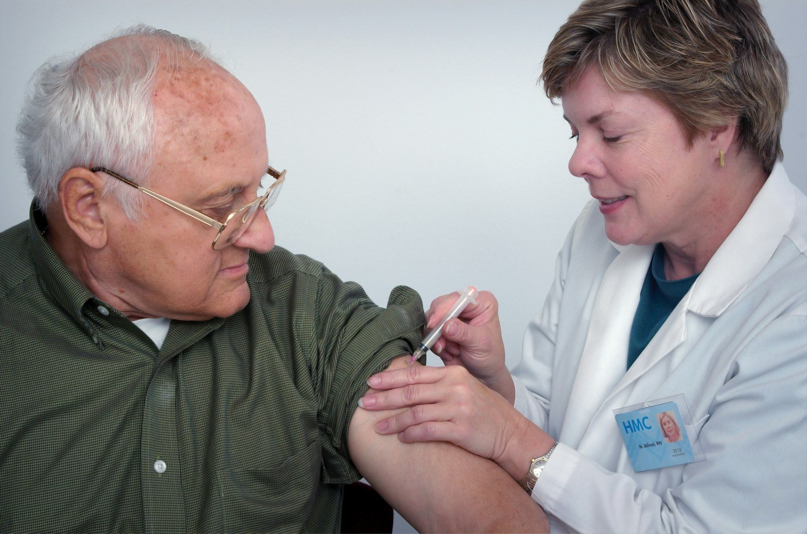 An older adult receiving a vaccination in the arm