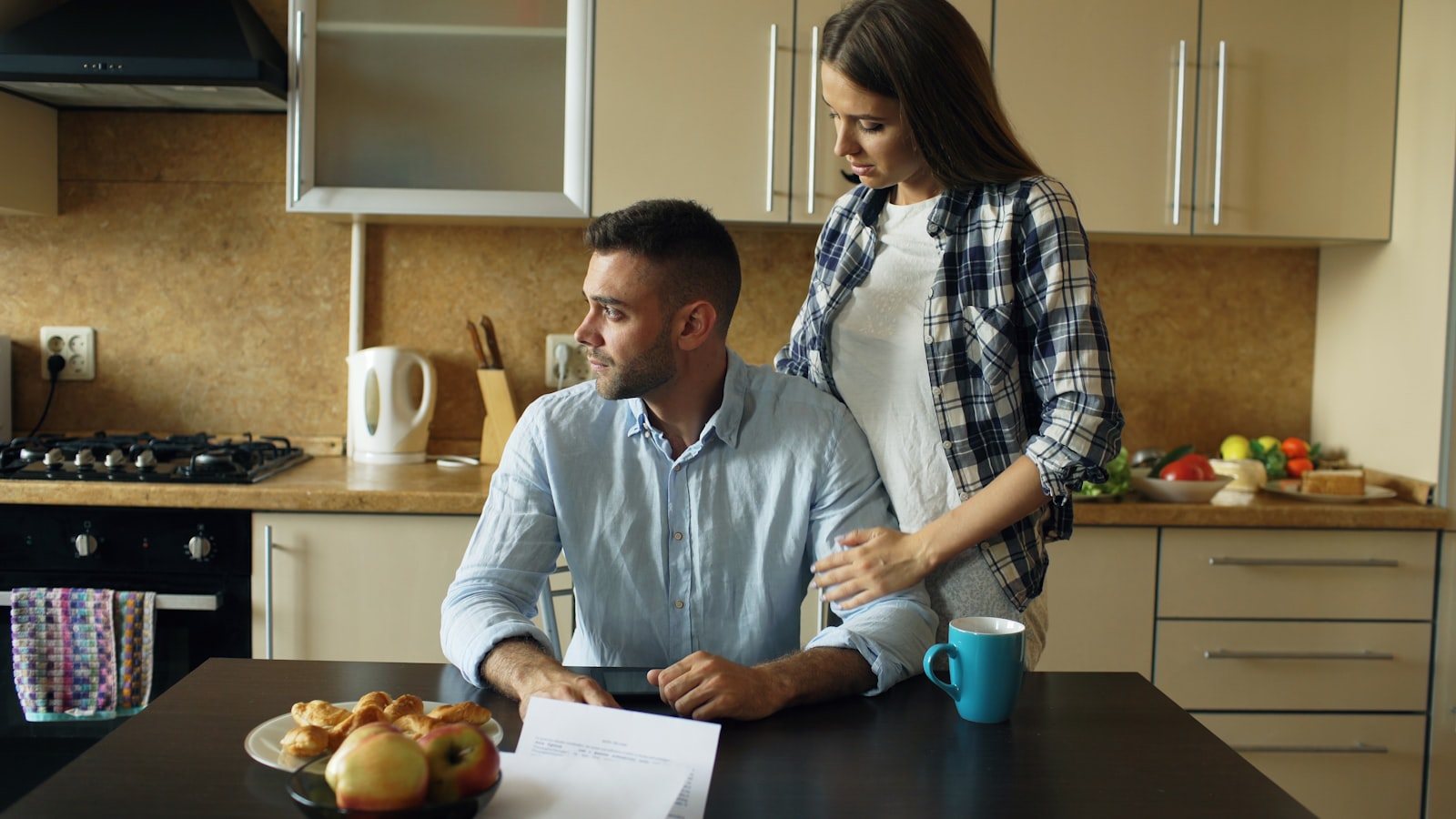 Two people talking at a kitchen table