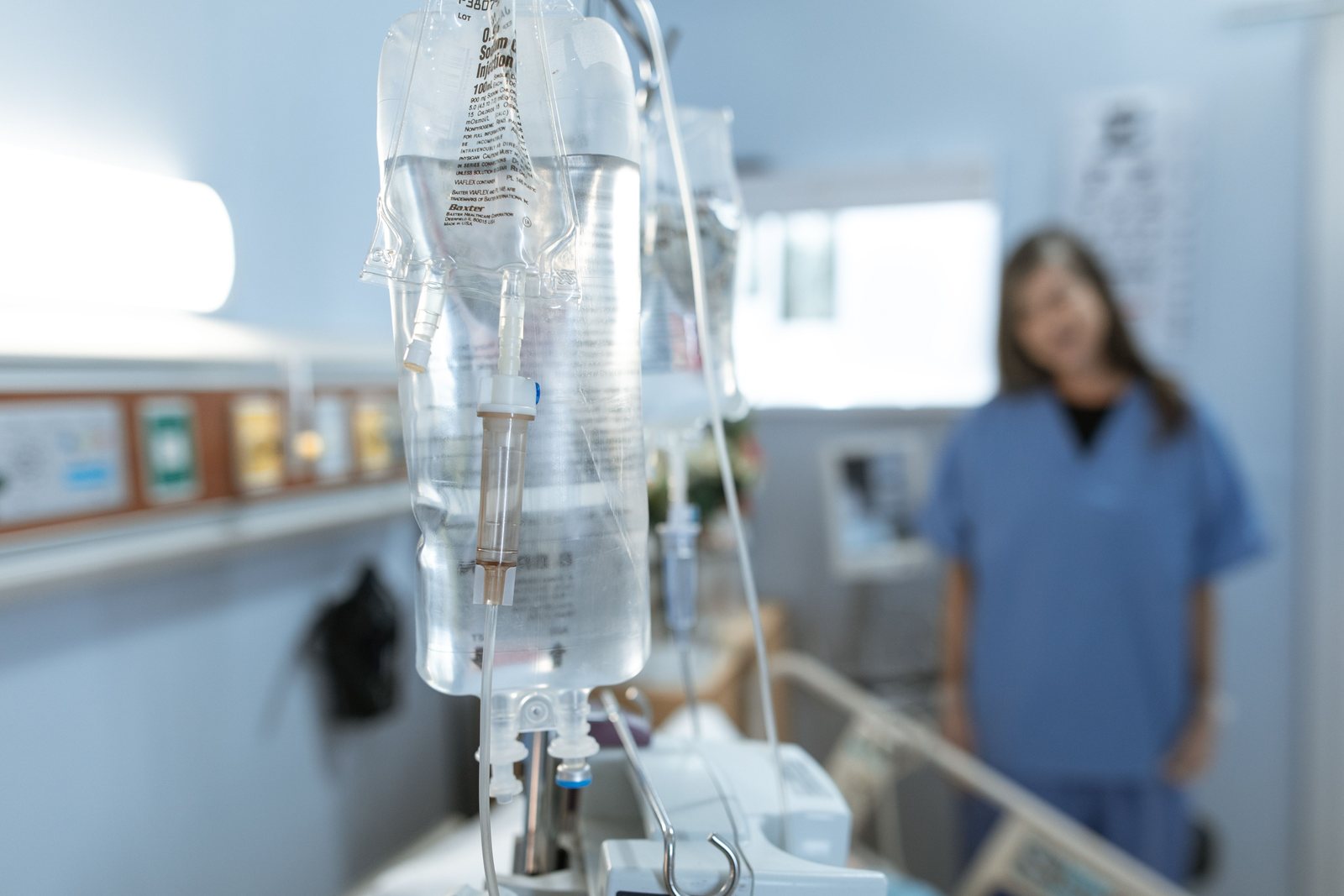 An intravenous drip with a nurse in the background