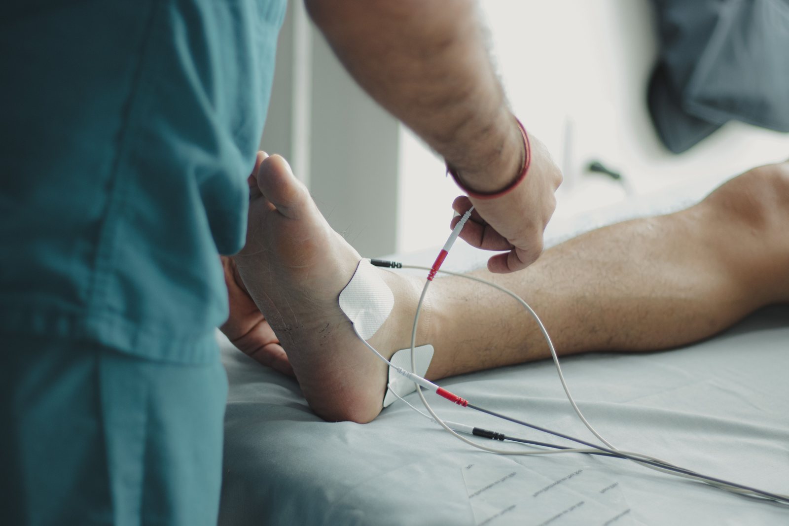 A clinician examining a patient's foot with medical equipment